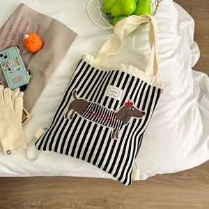 Detailansicht der schwarz-weiß gestreiften Beuteltasche mit brauner Dackel-Stickerei