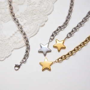 Detailed flat lay of star pendant necklaces in gold and silver over a lace background