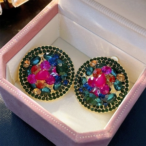 Close-up of luxury vintage round clip-on earrings with colorful rhinestones in a gift box
