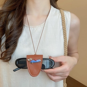 Detail of brown leather dachshund glasses holder necklace with cute cartoon design charm