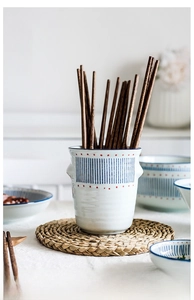 Detailed view of hand-painted Japanese ceramic chopstick holder with wooden utensils