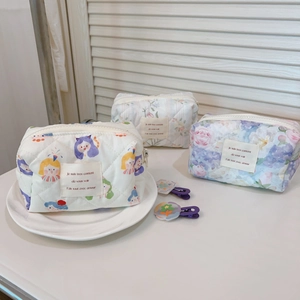 Close-up of quilted cotton floral cosmetic bags with vintage French labels and zippers