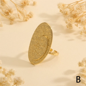 Detailed view of adjustable gold-plated hammered texture oval ring on warm background