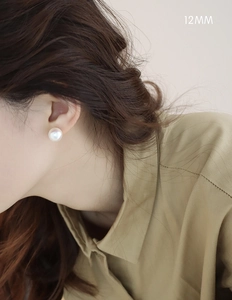 Close-up of 12mm white pearl earrings on model showing glossy finish and elegant fit