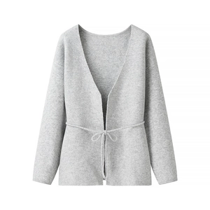 Minimalist light gray knit cardigan with V-neck, waist tie, and ribbed cuffs on white background