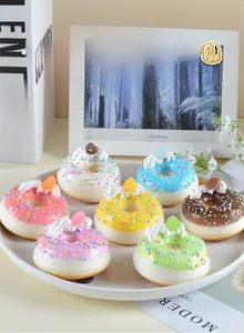 Makroaufnahme bunter PU-Donuts mit künstlichem Sahnehäubchen auf einem weißen Teller