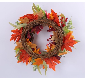 Detailed view of autumn wreath with vibrant maple leaves and red berries on a vine base.