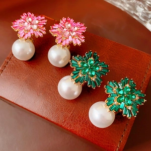 Detail view of flower-shaped stud earrings with sparkling crystals and elegant pearls