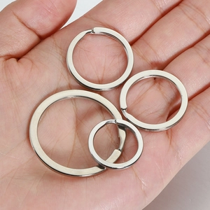 Hand holding four sizes of flat silver stainless steel split key rings for DIY jewelry