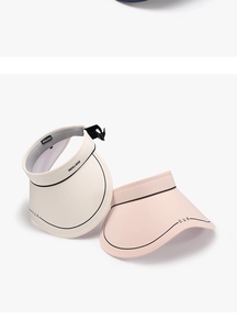 Detail of adjustable straps and brand logo on sun visors in cream and pink colors