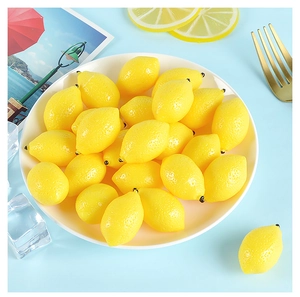 Close-up of artificial mini yellow lemons with realistic texture in a white ceramic dish