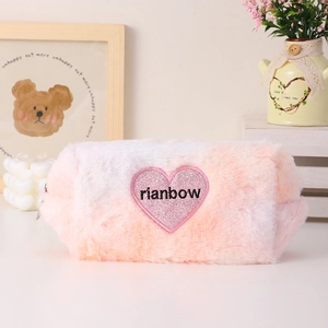 Macro detail of plush pink and white gradient makeup bag with embroidered heart patch
