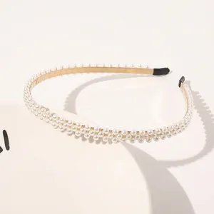 Detail view of gold metal headband with three rows of elegant white pearls for women