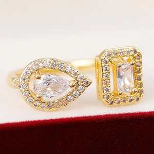 Close-up of gold open ring featuring sparkling pear and rectangular zircon stones