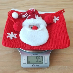 Vue détaillée du poids de 55,7g d'un sac cadeau de Noël en tricot rouge