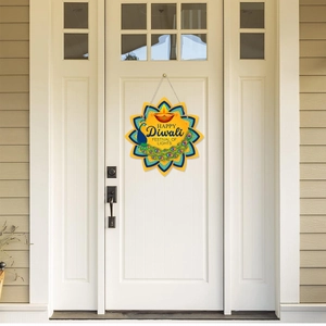 Detail of Happy Diwali star sign with peacock and lamps hanging on a white front door