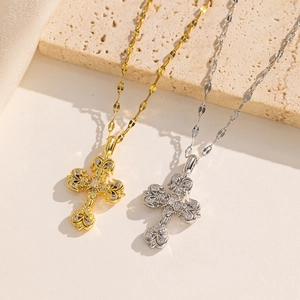 Vintage gold and silver cross necklaces with engraved details on stone background
