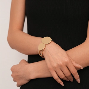Close-up of a double-layered irregular gold geometric cuff bracelet on a woman wrist