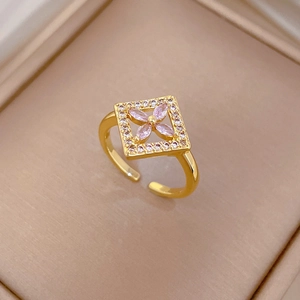 Macro detail of square gold ring with lavender petal stones and zircon pavé edges