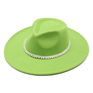 Close-up of light green wool fedora hat featuring elegant white pearl bead trim detail