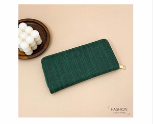 Macro shot of dark green textured lady's purse with golden zipper and vintage finish