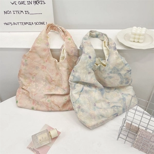 Detalle del bolso tote tie-dye de estilo coreano con bordado de lazo en entorno lifestyle