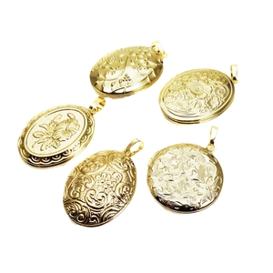 Five gold plated oval locket pendants with detailed embossed floral patterns for jewelry