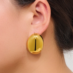 Minimalist large gold oval stud earrings in polished stainless steel on a female model