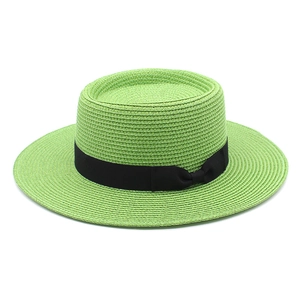 Detailed weave of light green boater hat with a classic black ribbon and small bow