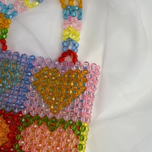 Close-up of colorful handmade beaded tote bag showing rainbow acrylic floral patterns