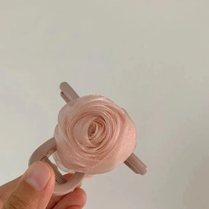 Détail macro de la pince à cheveux rose en organza avec pétales de tissu délicats