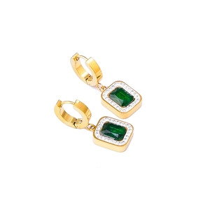 Boucles d'oreilles dorées avec zircon vert rectangulaire et cristaux blancs sur fond blanc