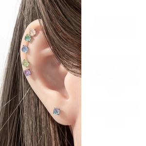 Close-up of model wearing colorful round cut zircon ear studs in a multi-piercing style