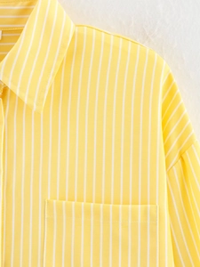 Detail of yellow striped shirt showing the collar, breast pocket and woven fabric texture