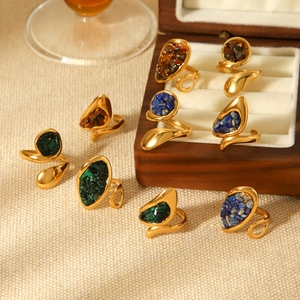 Vintage gold wavy stainless steel rings set with natural stones on a jewelry tray