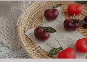 Detalle macro de velas de cereza realistas con tallos verdes sobre encaje vintage