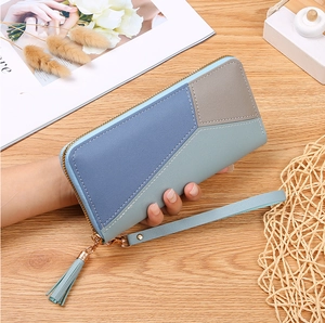 Detail of color-block patchwork long wallet with tassel zipper and wrist strap