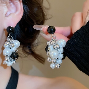 Close-up of cluster bead earrings with black pearls and silver metallic beads on model
