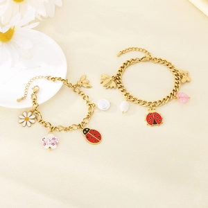 Detail of gold charms bracelet featuring colorful enamel bees, ladybugs and flowers