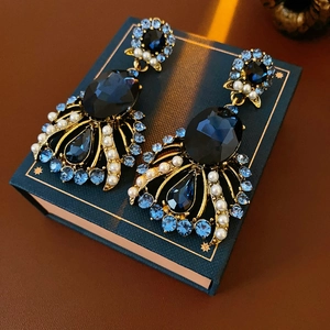 Macro detail of vintage baroque earrings with navy faceted stones and pearls