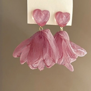 Macro shot of pink chiffon petal tassel earrings with a pearlescent heart stud