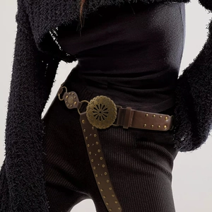 Gros plan sur ceinture en cuir marron avec boucle en bronze ciselé et rivets décoratifs
