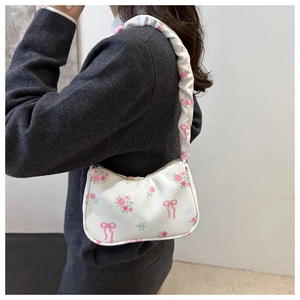 Detail of white shoulder bag with pink roses, bow prints and pleated ruffle strap