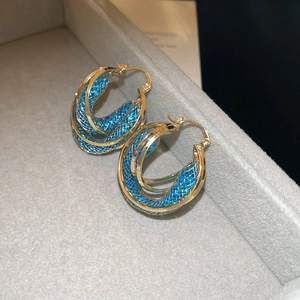 Detailed macro of gold twisted triple hoops with electric blue crystal mesh inlay