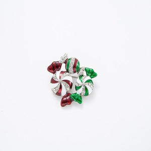 Detailed view of red and green enamel candy brooch with sparkling inlaid rhinestones