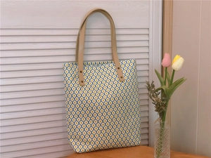Détail du sac cabas floral avec motifs géométriques et poignées en cuir