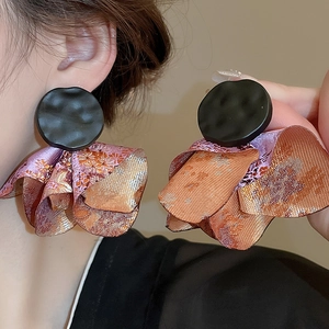 Detailed close-up of large petal earrings with black studs and purple fabric petals