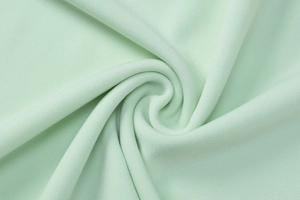 Détail macro du tissu texturé vert clair avec ondulations douces et maille délicate