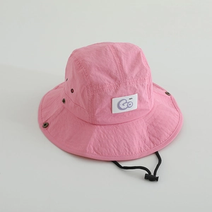Détail du chapeau bob rose enfant à séchage rapide avec patch GO et cordon ajustable