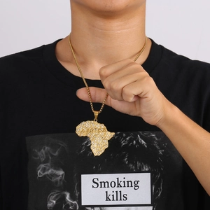 Detailed view of a gold hip-hop Africa map pendant with iced-out crystals on a model